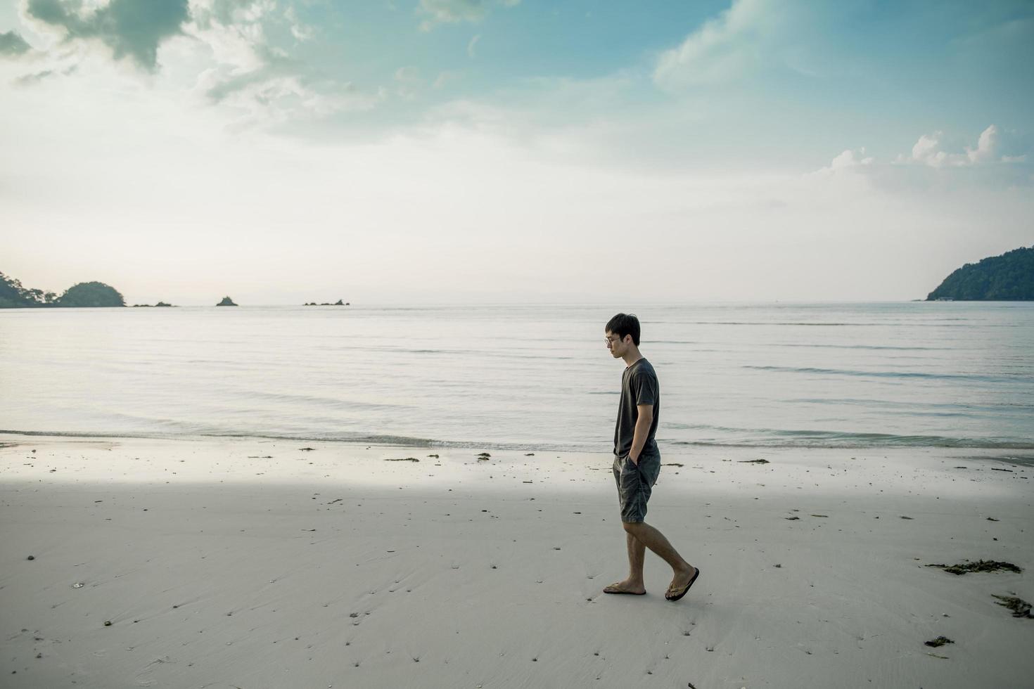 een man die op het strand loopt foto