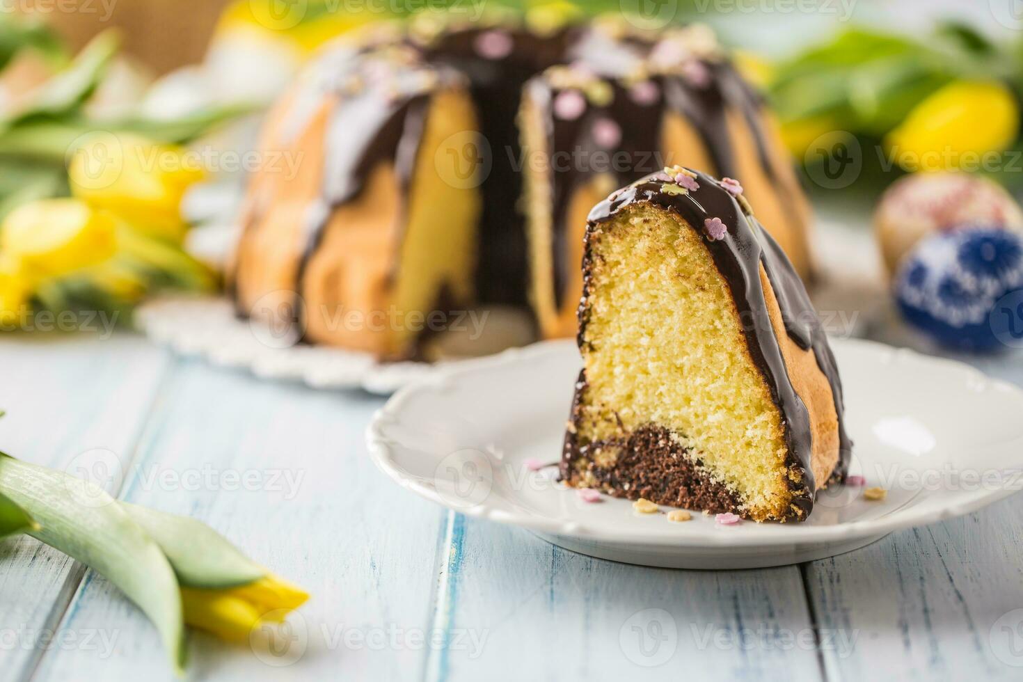 heerlijk vakantie Slowaaks en Tsjechisch taart babovka met chocola glazuur. Pasen decoraties - voorjaar tulpen en eieren foto