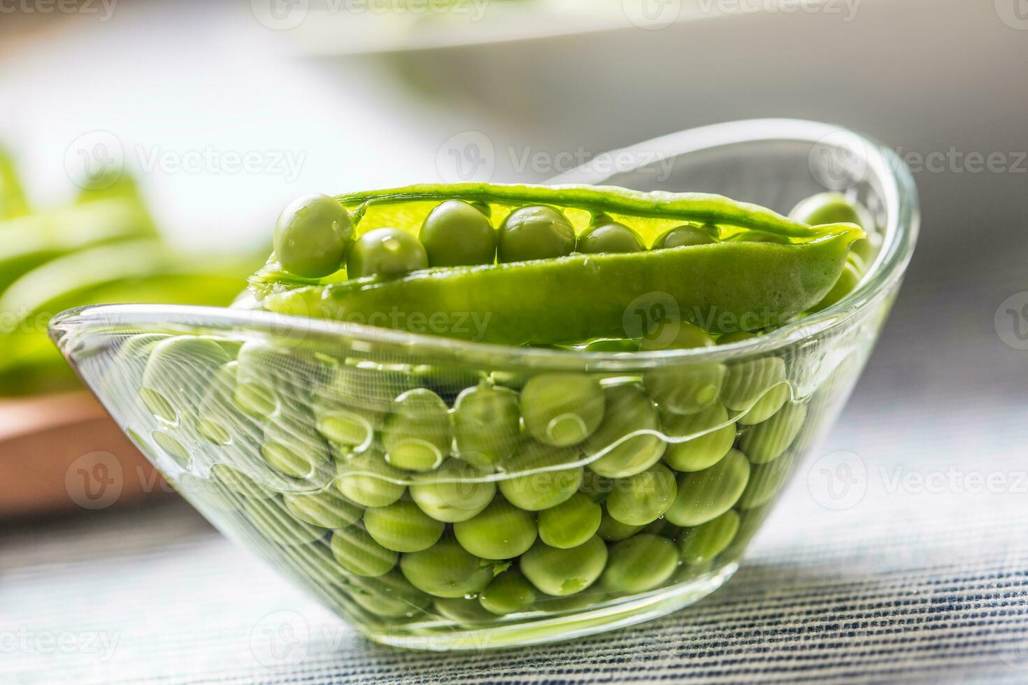 vers groen erwt zaden in kom Aan keuken tafel foto