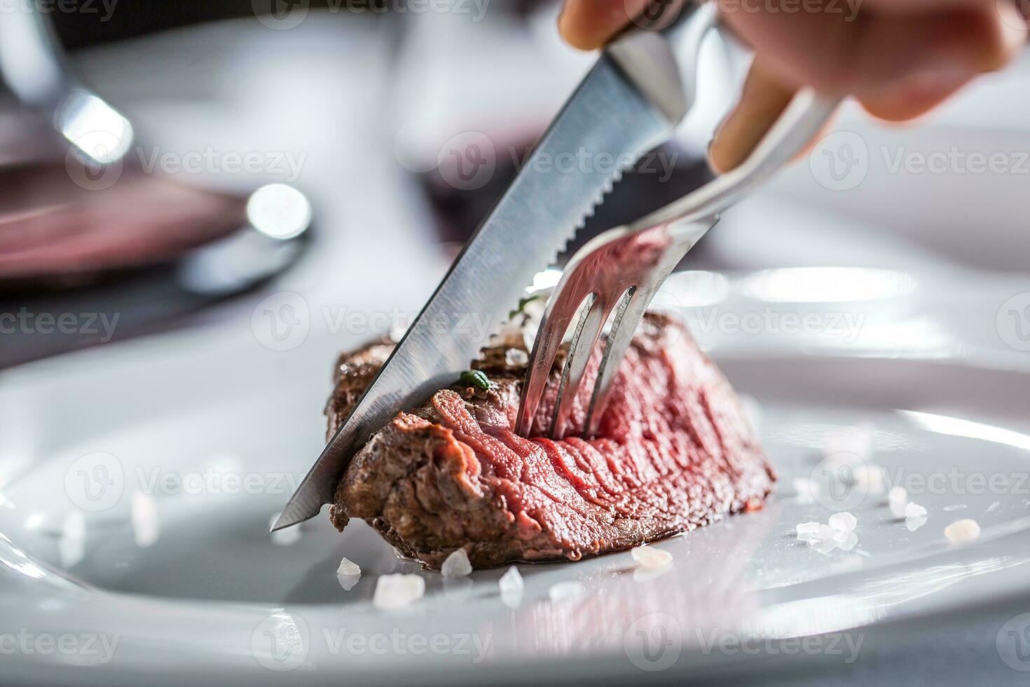rundvlees lende steak Aan wit bord en rood wijn in kroeg of restaurant foto