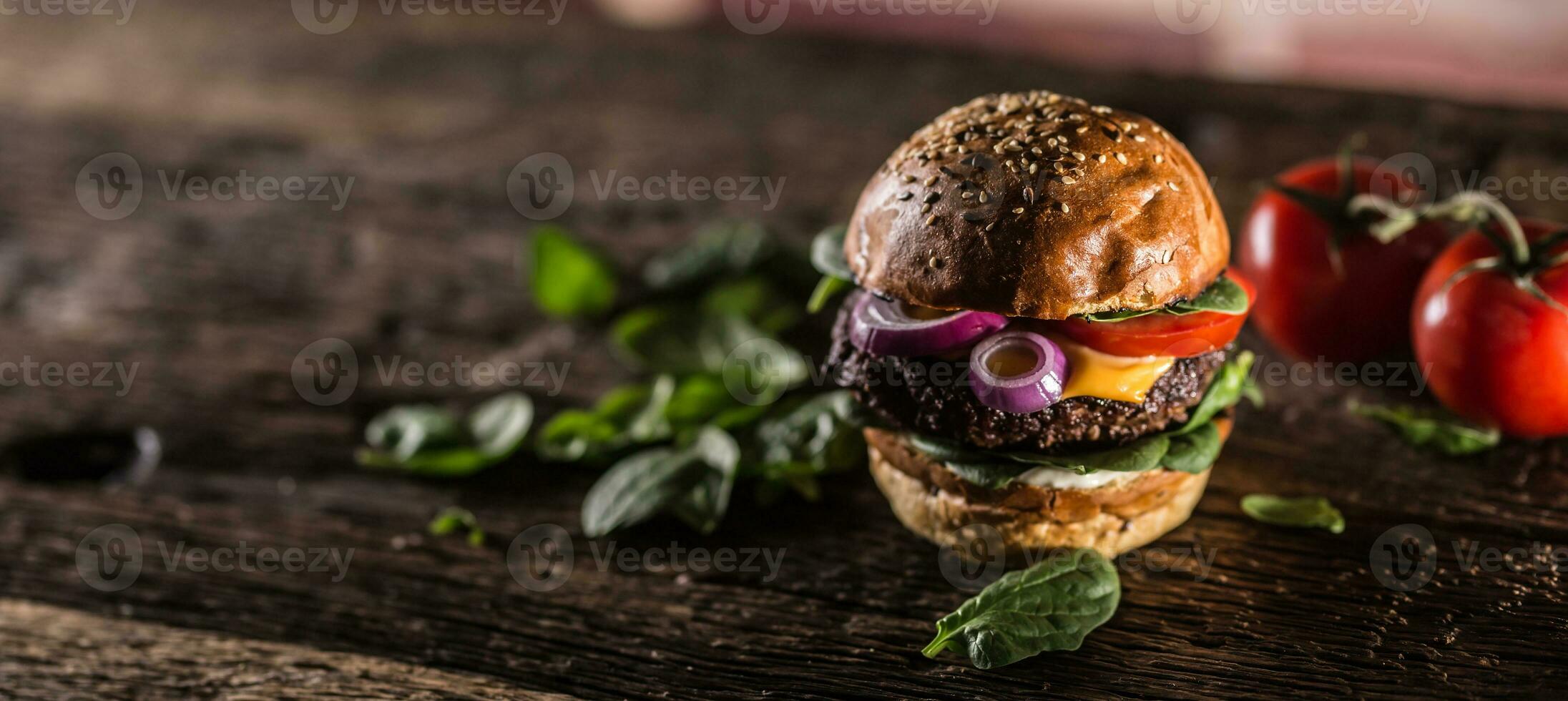 smakelijk rundvlees hamburger met spinazie bladeren salade ui tomaat en kaas foto