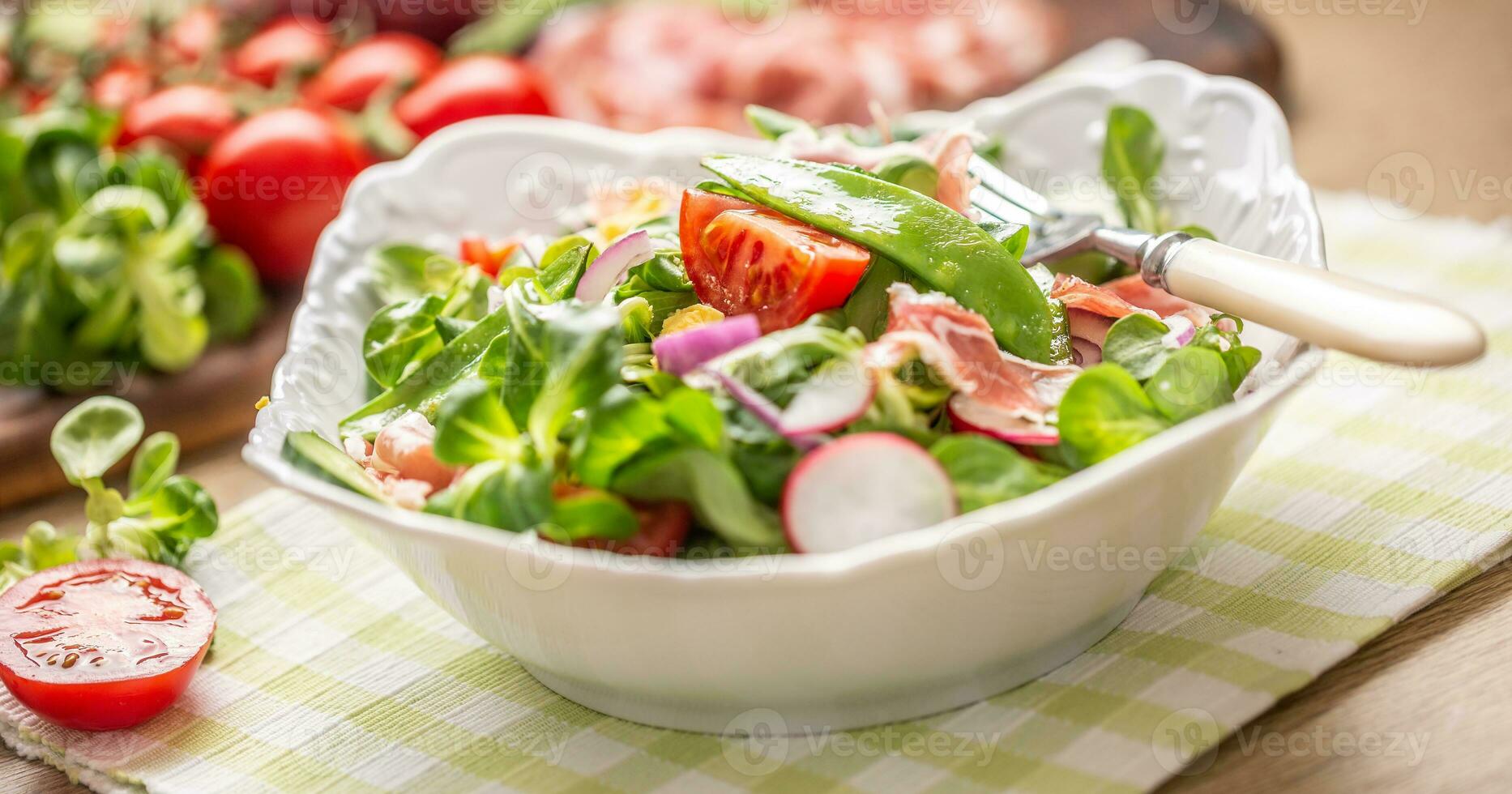 vers voorjaar salade met groen bladeren tomaten ei radijs rood ui jong erwten prosciutto feta kaas en olijf- olie foto