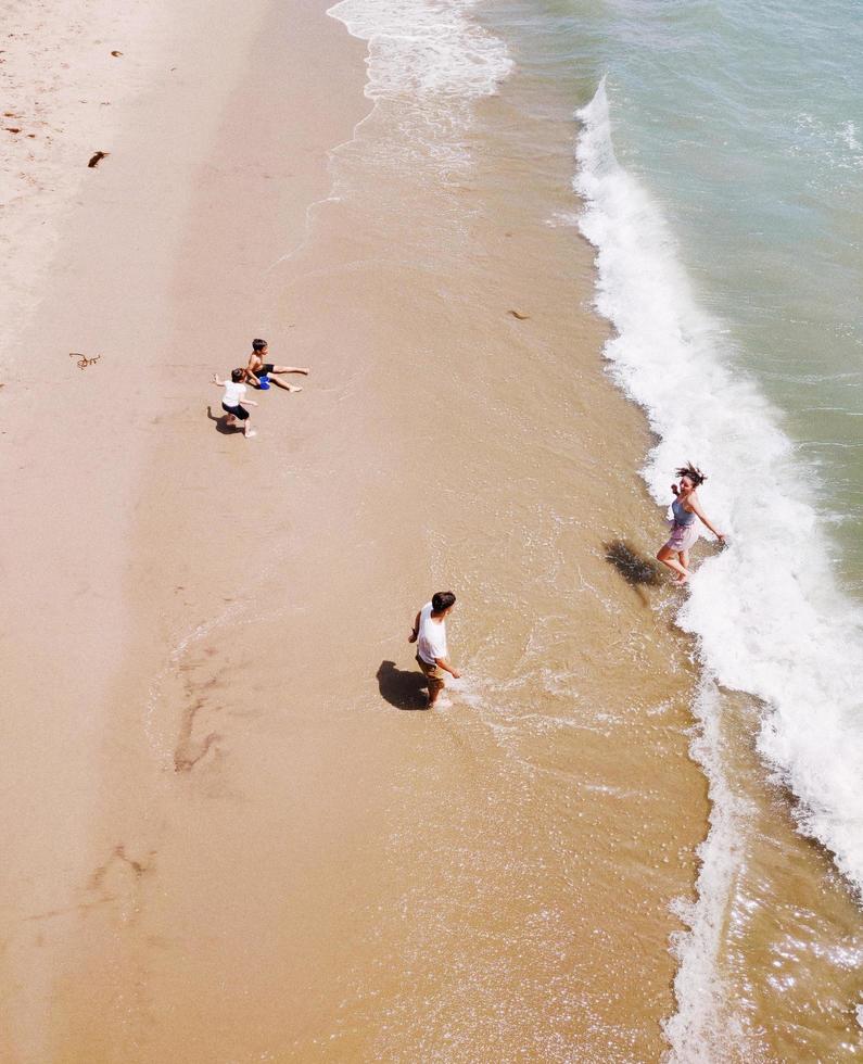 los angeles, californië 2019 - gezin van vier speelt overdag langs de kust foto