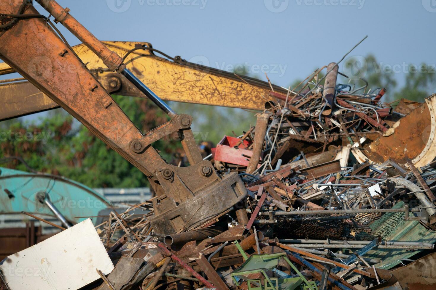 graafmachine magneet hijs- staal kladjes van recycling materialen stapel Bij vodje werf in recycling fabriek. graafmachine met elektro en magnetisch zuignap magneet klauw. speciaal graafmachine. vodje metaal magneet. foto