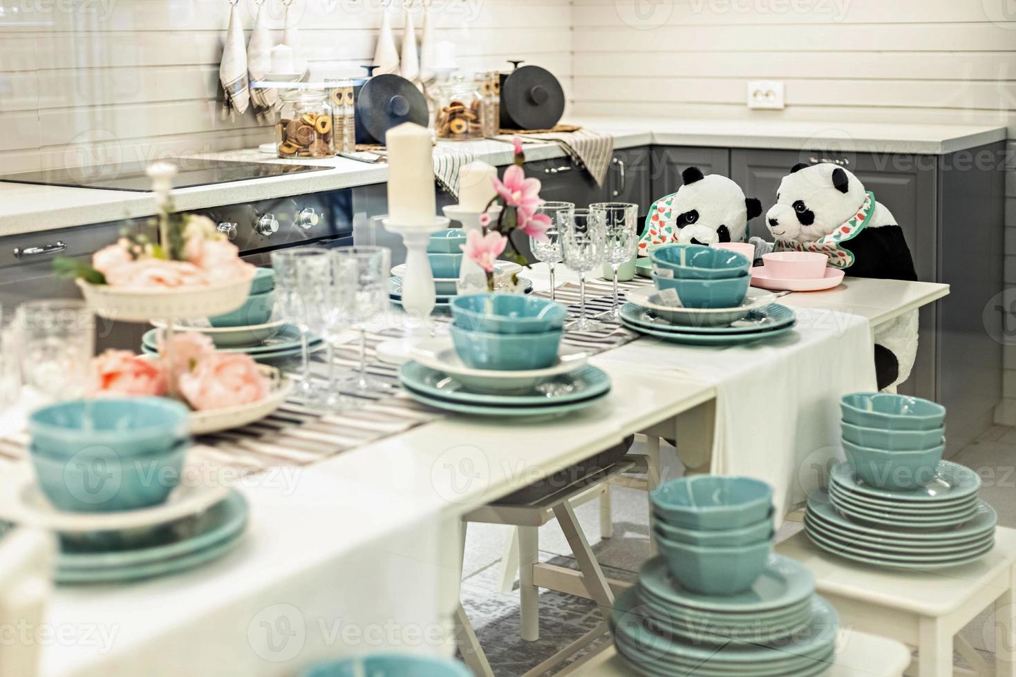 twee panda's aan tafel tussen de gerechten foto