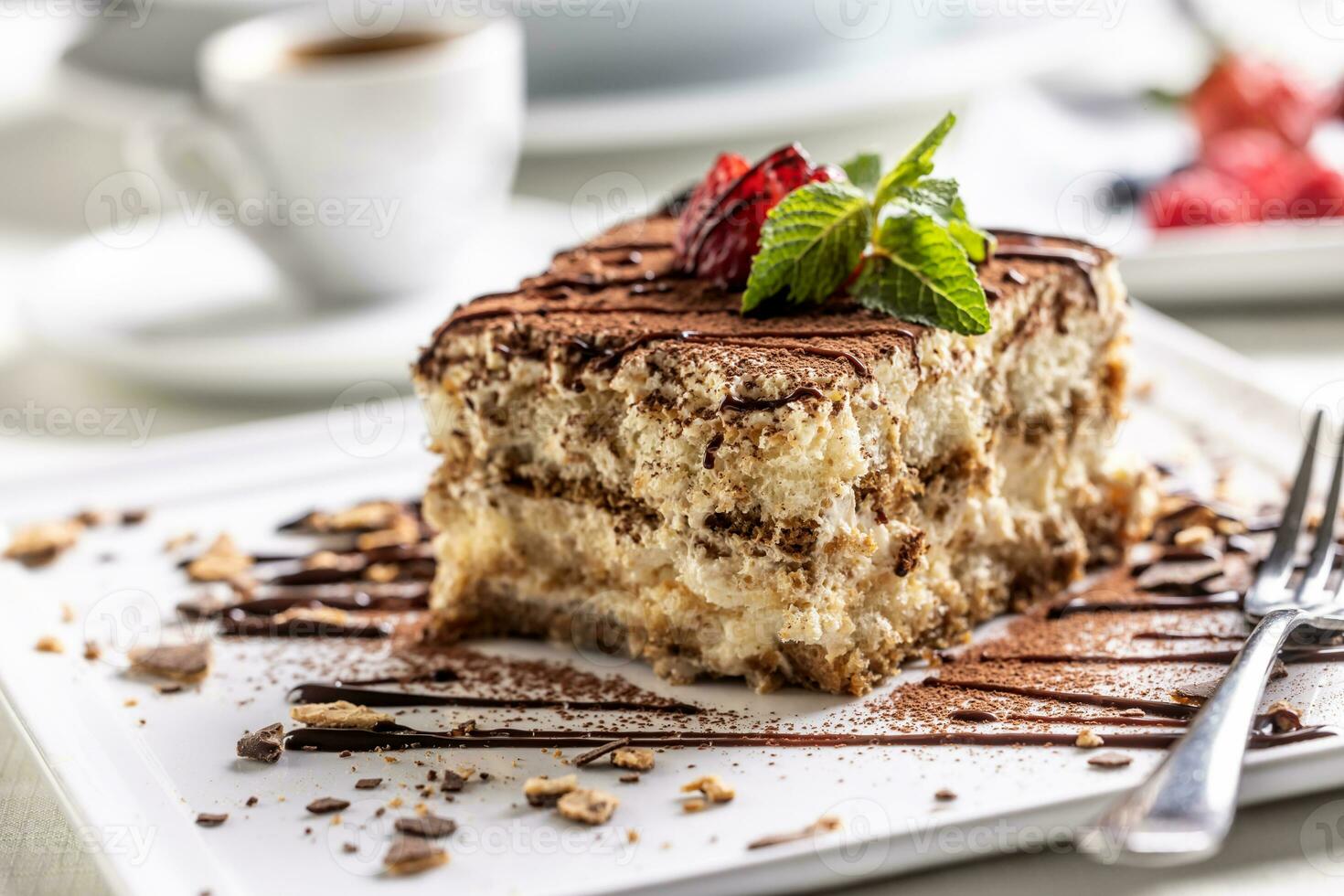 traditioneel Italiaans tiramisu taart, geserveerd Aan een decoratief bord met een espresso foto