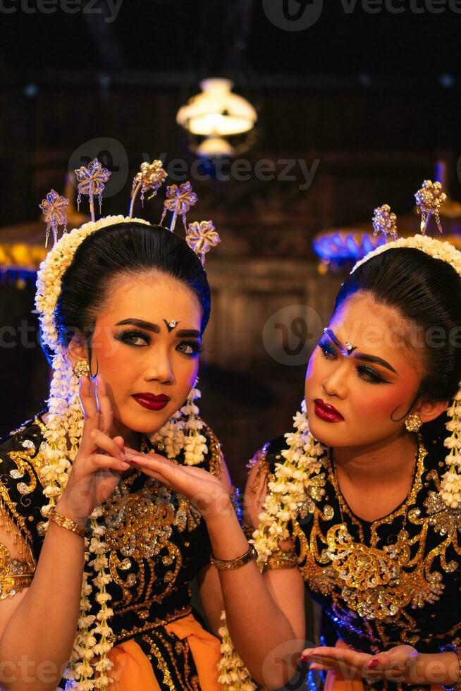 twee Javaans dansers in geel sjaals nemen afbeeldingen met belachelijk gezichten foto