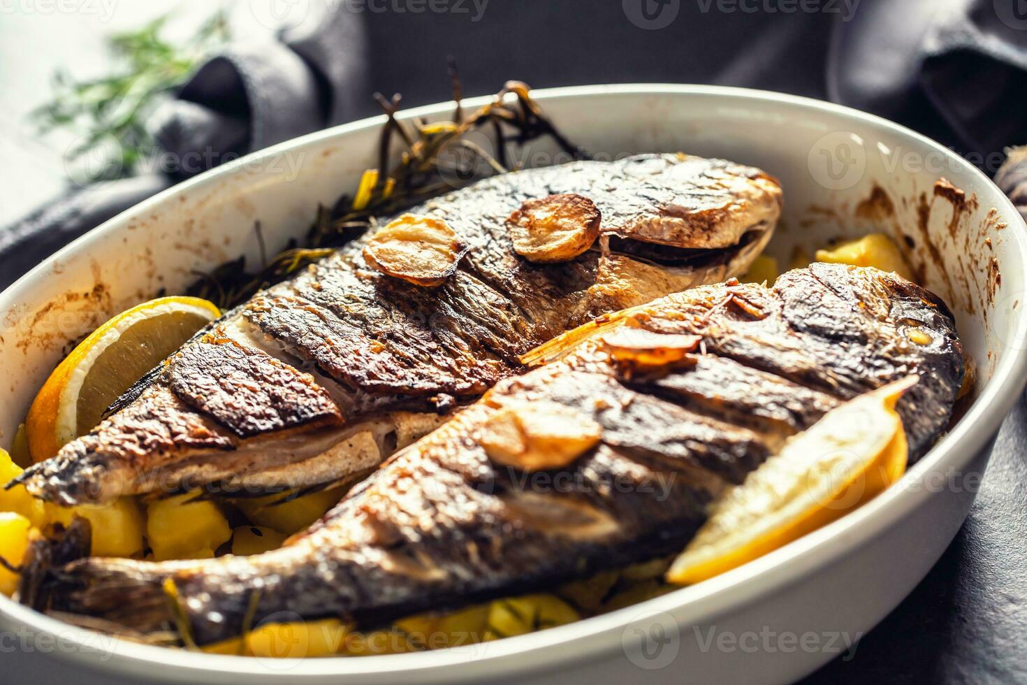 geroosterd middellandse Zee vis brasem met aardappelen rozemarijn en citroen foto