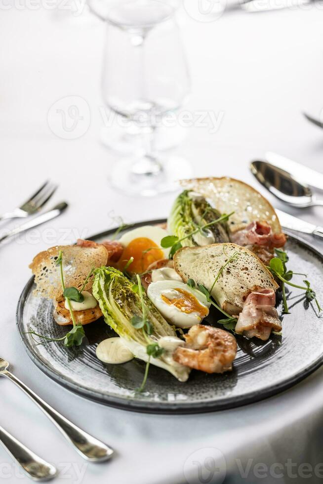 modern versie van een ceasar salade met garnalen geserveerd in een chique restaurant foto