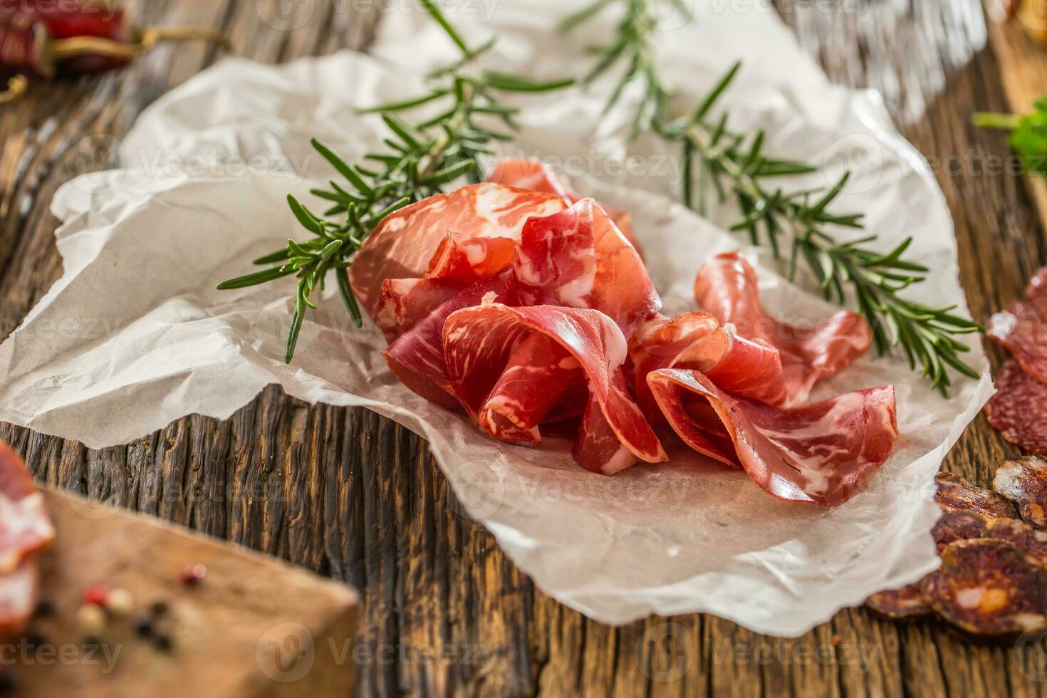 prosciutto met vers rozemarijn Aan wit papier. foto