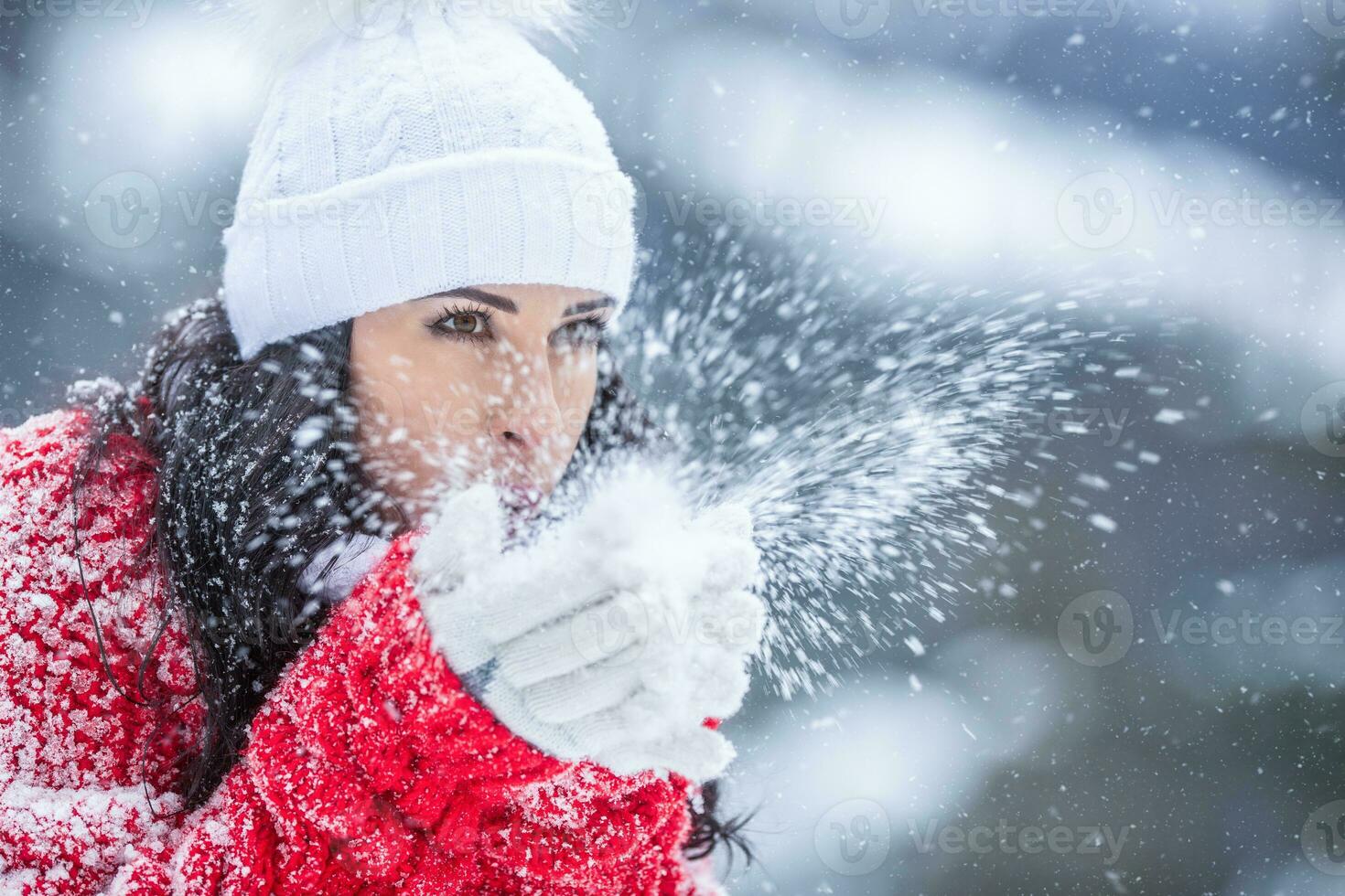 vrouw slagen sneeuw van haar handen Aan een verkoudheid winter dag foto