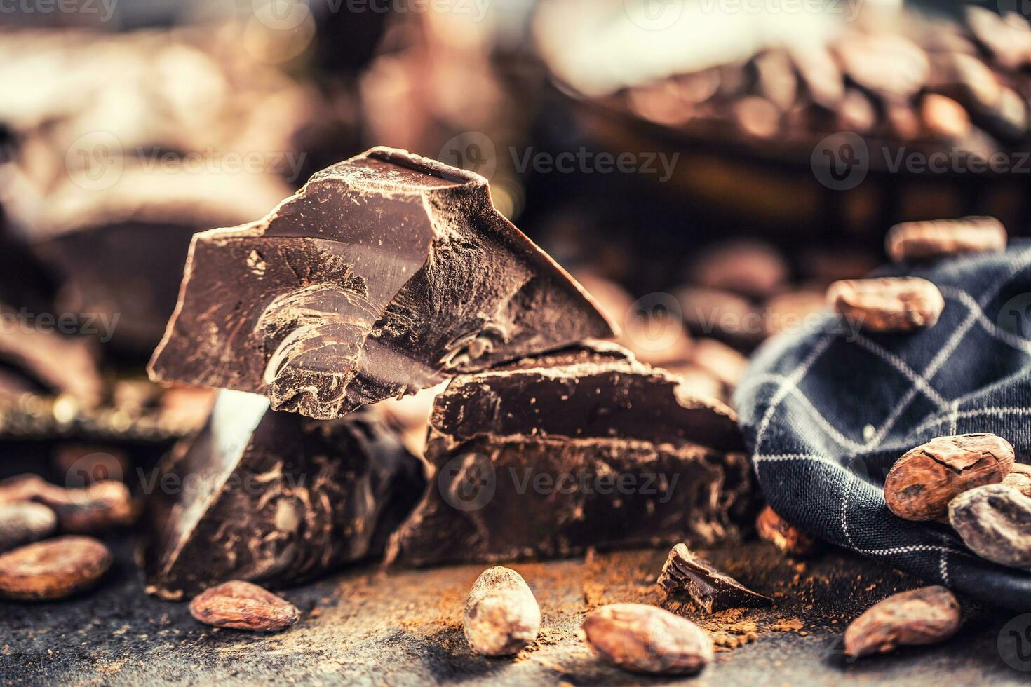 donker chokolate cacao bonen en poeder Aan beton tafel foto
