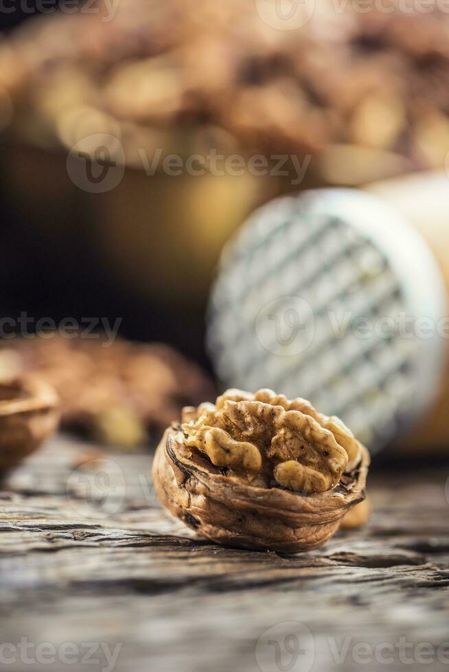 detailopname okkernoot kernel en geheel walnoten Aan oud houten tafel foto