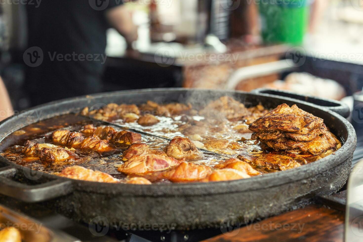 divers assortiment van vlees gebakken in een groot pan in een restaurant foto