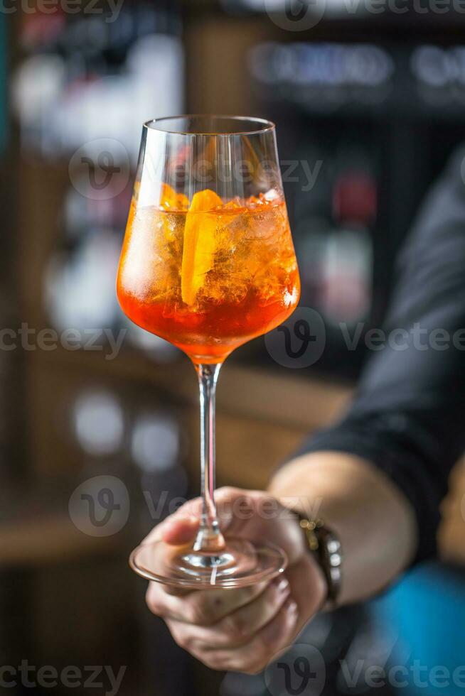 aperol spritz drankje. barman hand- Holding glas met aperol spritz drankje. foto