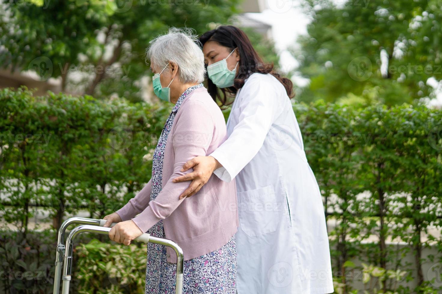 aziatische senior of oudere oude dame vrouw loopt met rollator en draagt een gezichtsmasker ter bescherming van de veiligheidsinfectie covid-19 coronavirus. foto