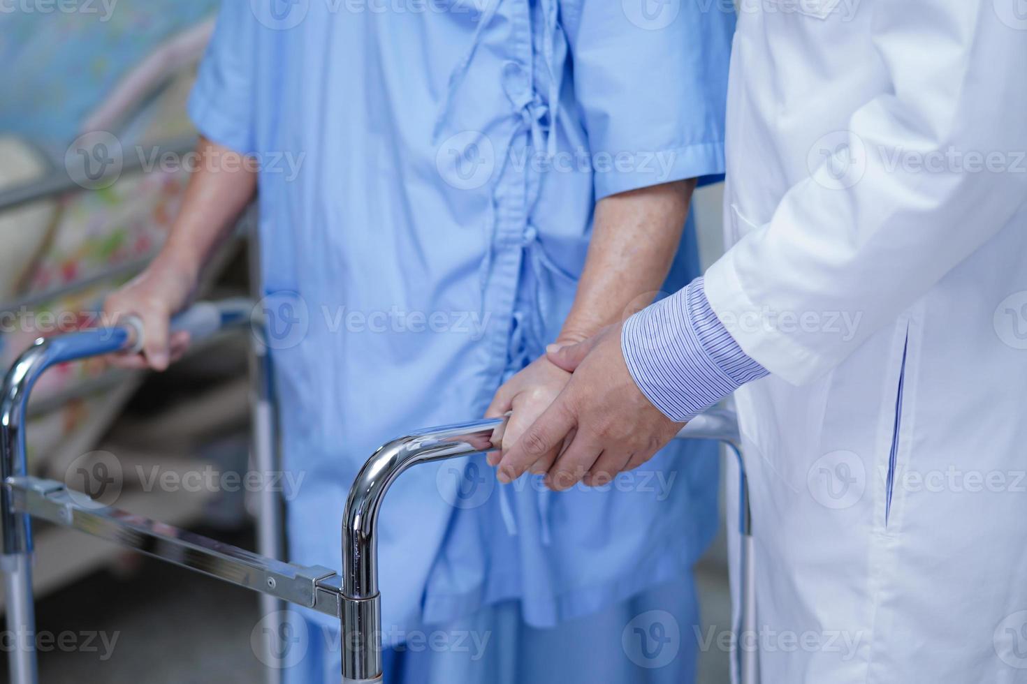 arts help aziatische senior of oudere oude dame vrouw patiënt lopen met rollator op verpleegafdeling ziekenhuis. foto