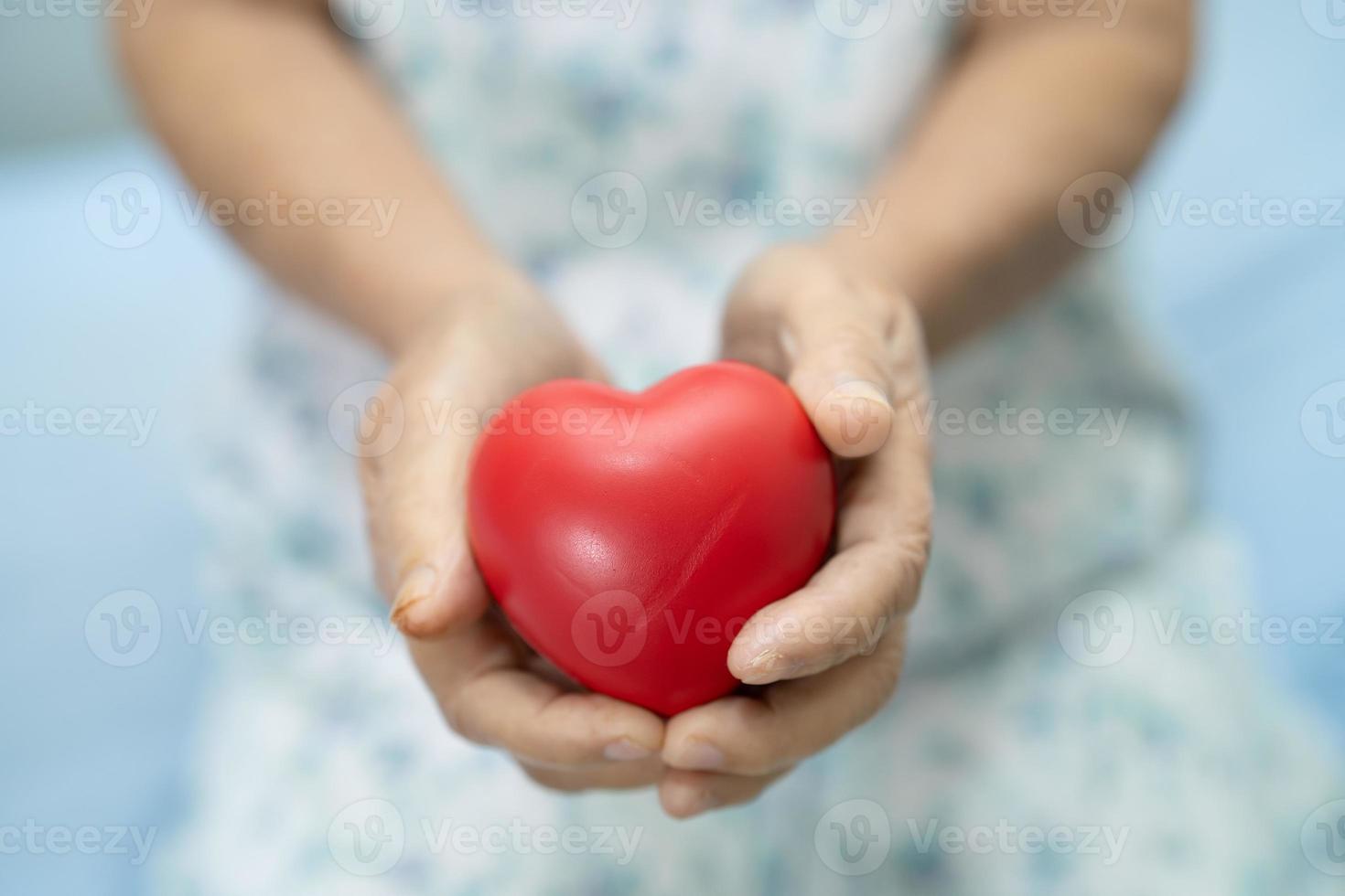 Aziatische senior of oudere oude dame vrouw patiënt met rood hart in haar hand op bed in verpleegafdeling, gezond sterk medisch concept foto