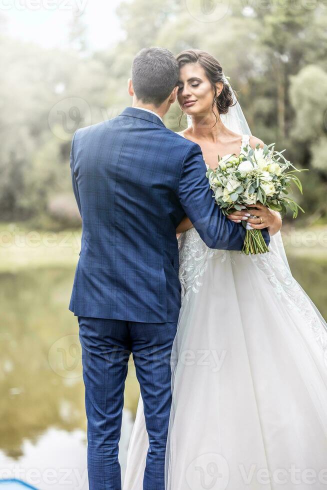 pasgetrouwde paar diep in liefde houden elk andere De volgende naar een meer buitenshuis foto