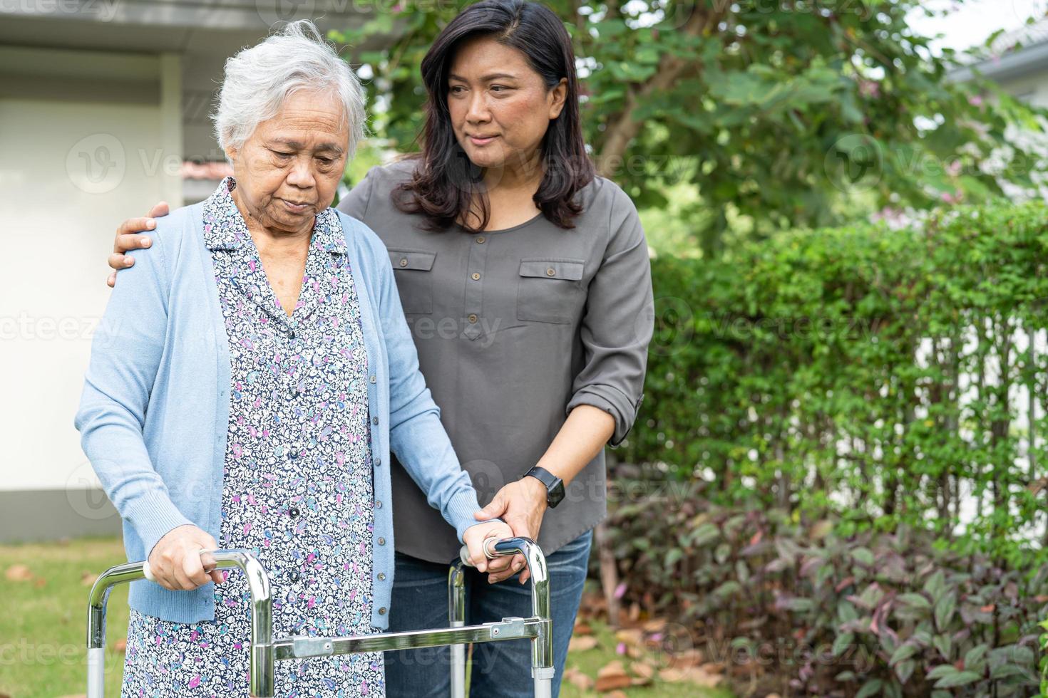 help en zorg aziatische senior of oudere oude dame vrouw gebruik rollator met een sterke gezondheid tijdens het wandelen in het park in een fijne frisse vakantie. foto