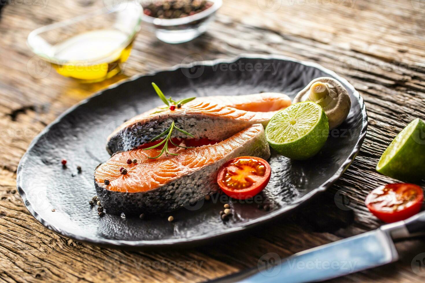 Zalm rauw steaks rozemarijn tomaten paddestoel limoen olijf- olie en specerijen. foto