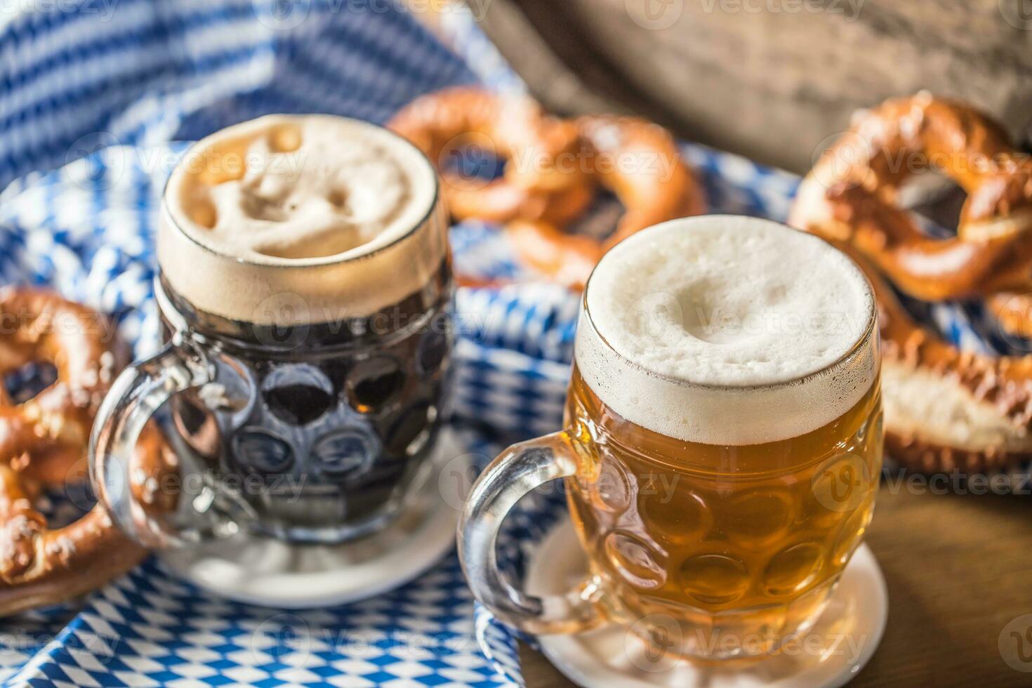 oktoberfeest twee bier met zoute krakeling houten vat en blauw tafelkleed foto