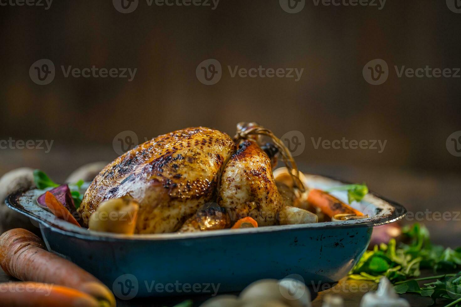 gebraden geheel kalkoen of kip in oud pan met groenten foto