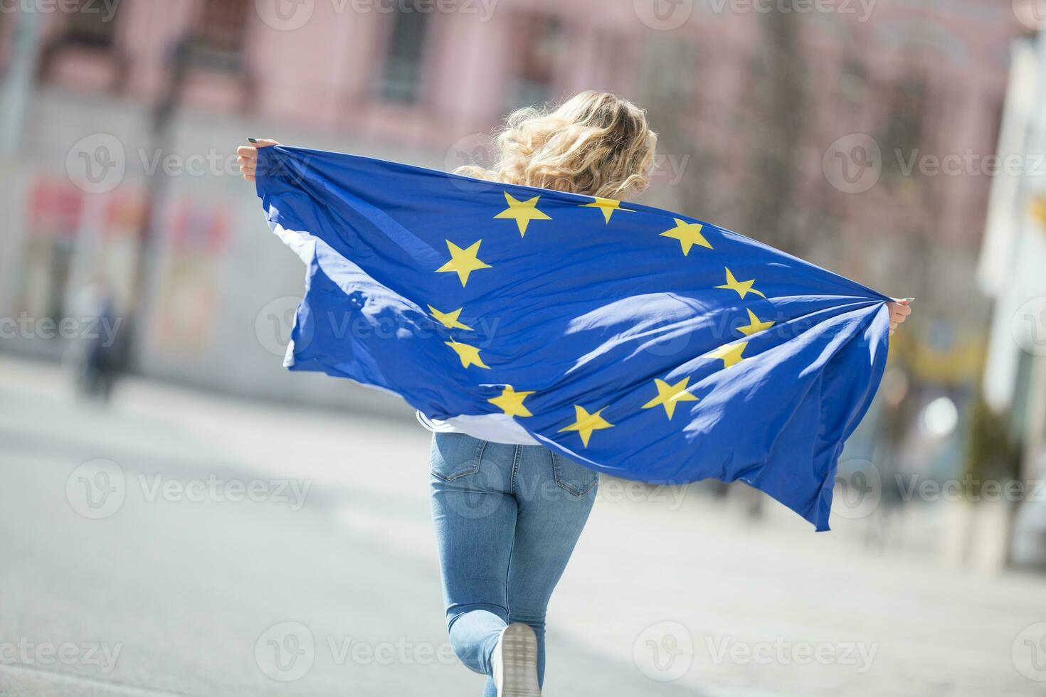 aantrekkelijk gelukkig jong meisje met de vlag van de Europese unie foto