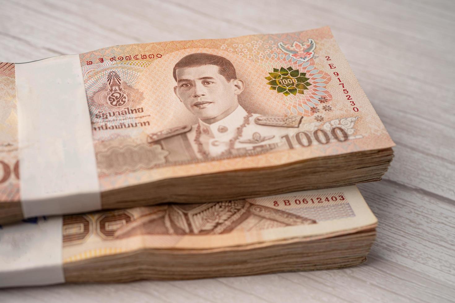 stapel Thaise baht-bankbiljetten op houten achtergrond, bedrijfsbesparingsconcept voor financiën. foto