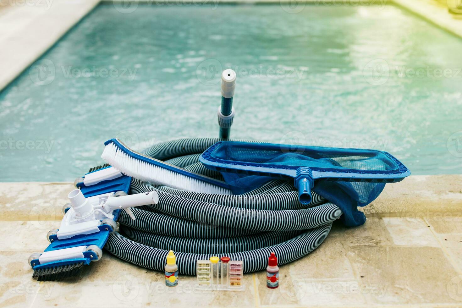 zwembad schoonmaak en onderhoud hulpmiddelen, beeld van zwembad schoonmaak en onderhoud uitrusting, vacuüm schoner, ph testen, blad picker en zwembad veger foto