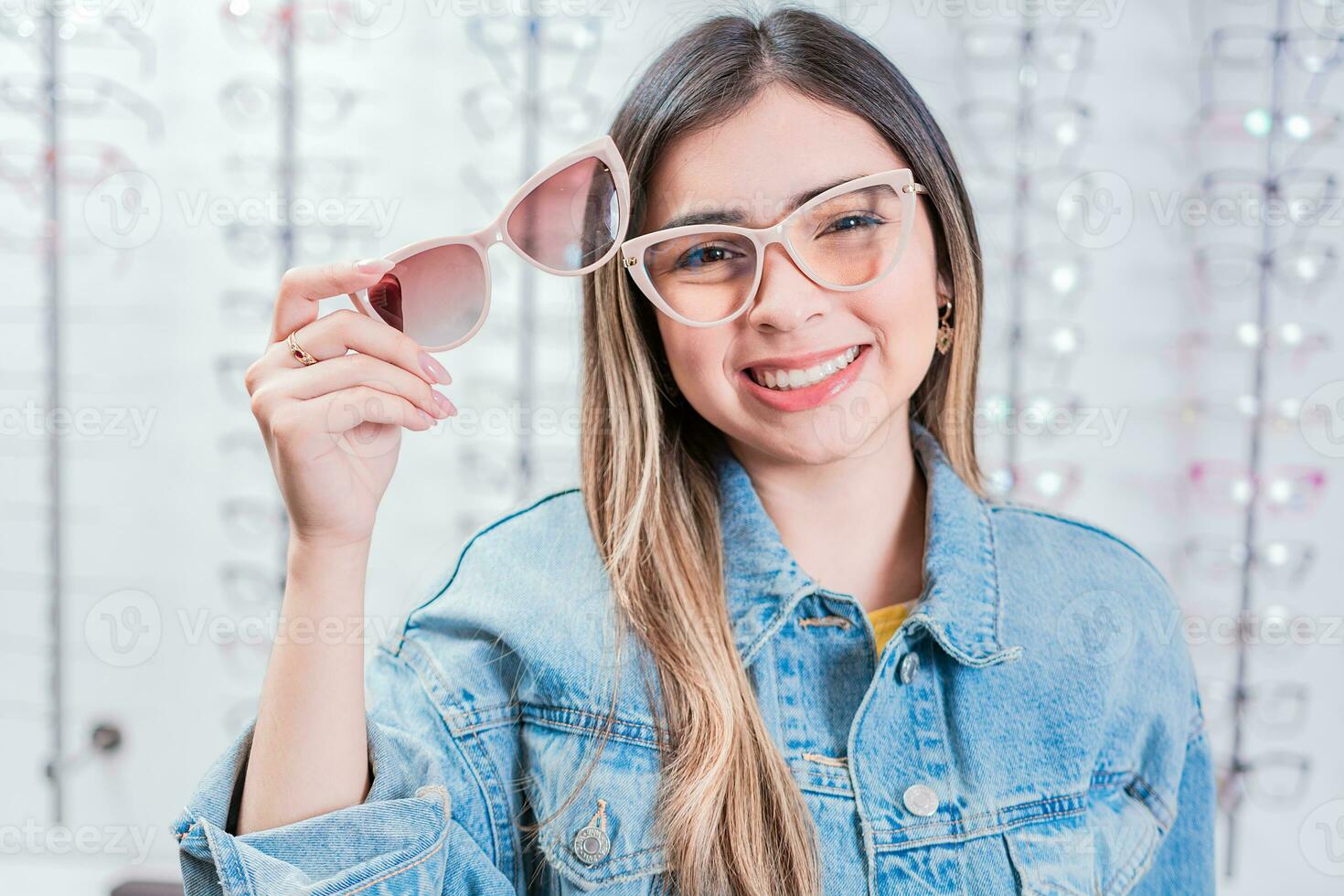 glimlachen vrouw klant proberen Aan bril in oog winkel. mooi meisje proberen Aan bril in een oog op te slaan foto