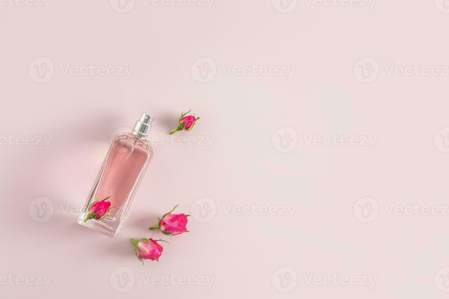 een mooi fles van vrouwen parfum of verstuiven Aan een roze achtergrond met klein rozenknopjes. top visie. een kopiëren ruimte. presentatie van de geur. foto