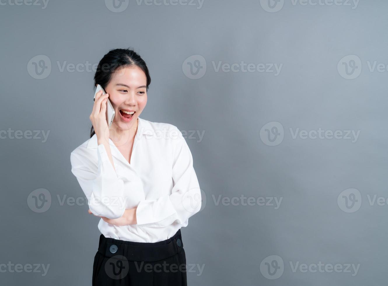 aziatische vrouw die mobiele telefoon gebruikt om zaken te praten foto