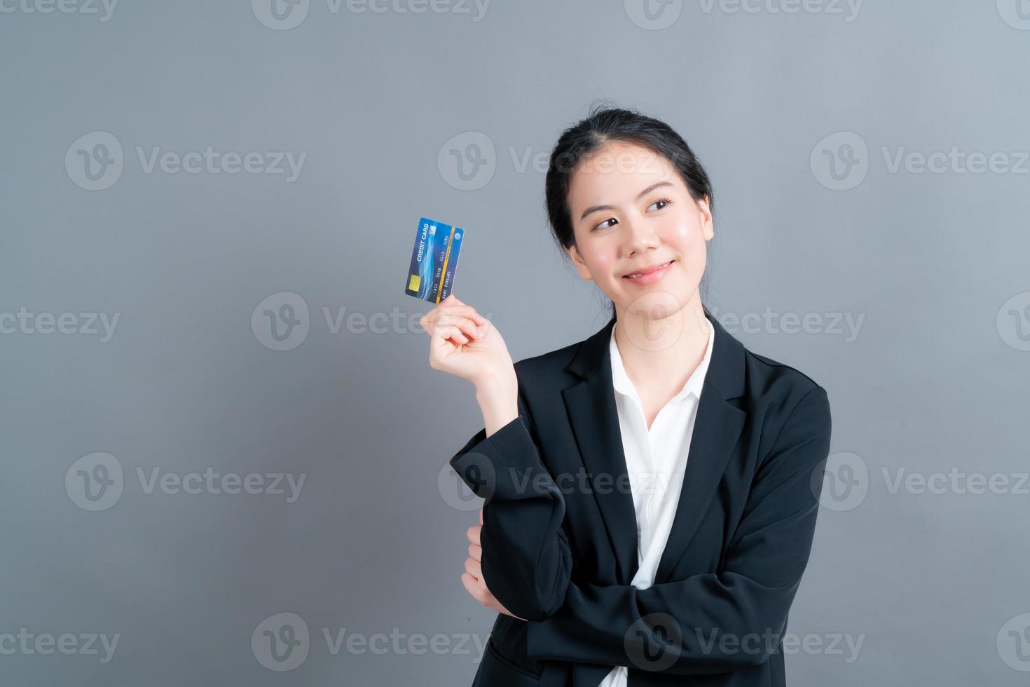 portret van een mooie jonge Aziatische vrouw die creditcard toont foto