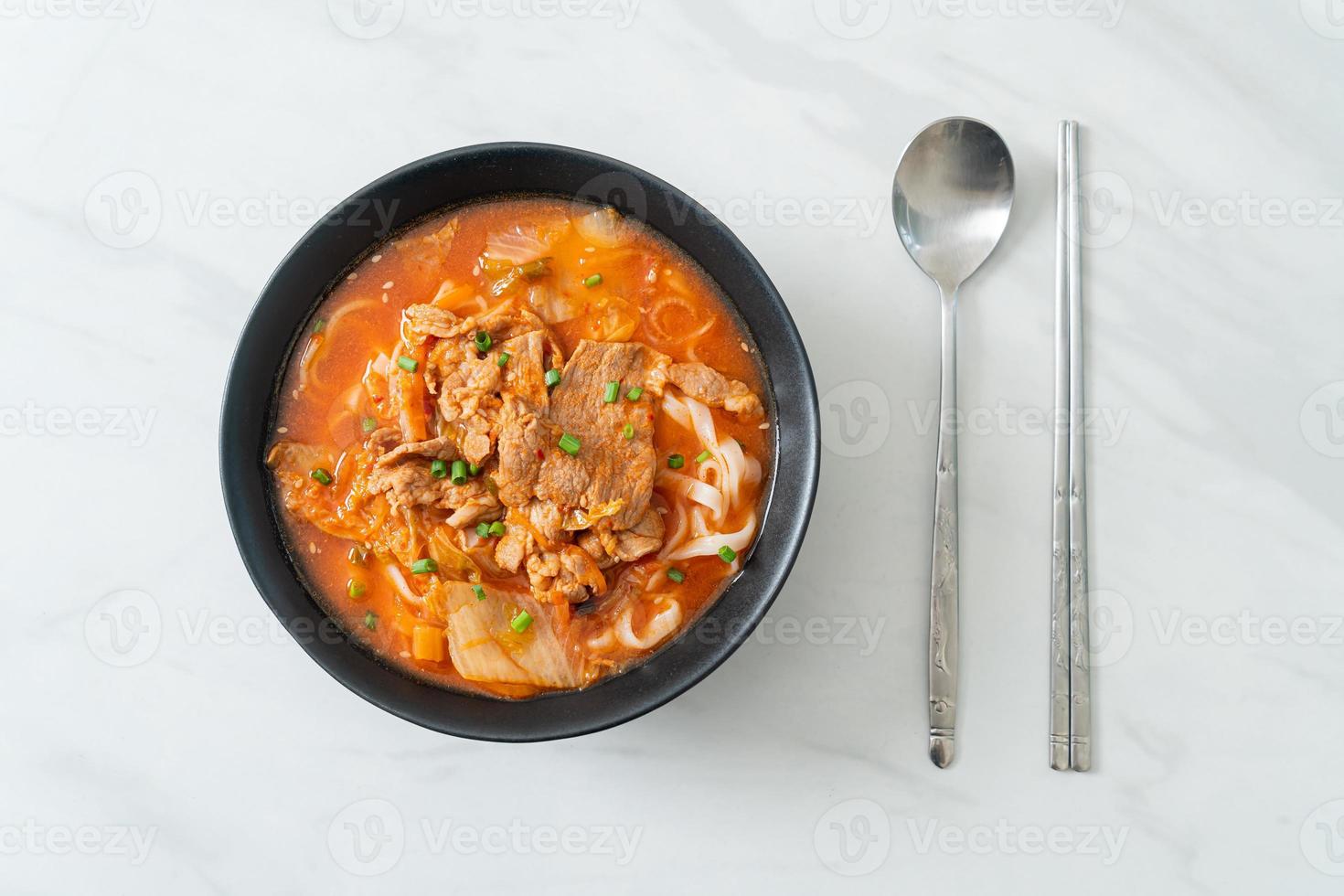 Koreaanse udon ramen-noedels met varkensvlees in kimchi-soep foto