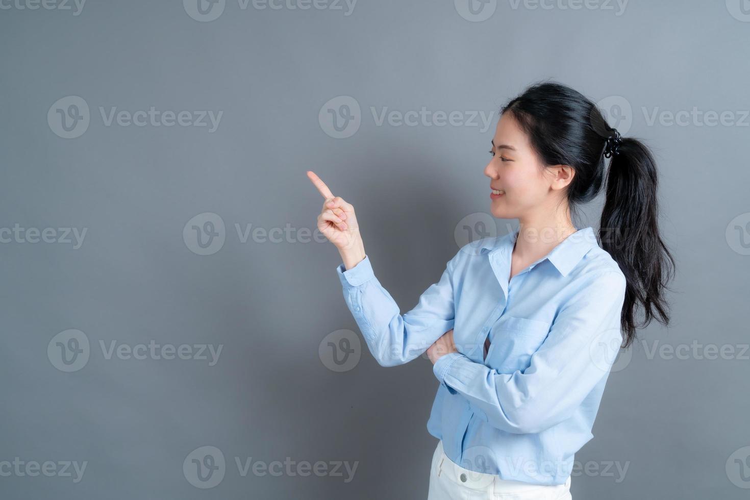 aziatische vrouw met hand die aan kant presenteert foto