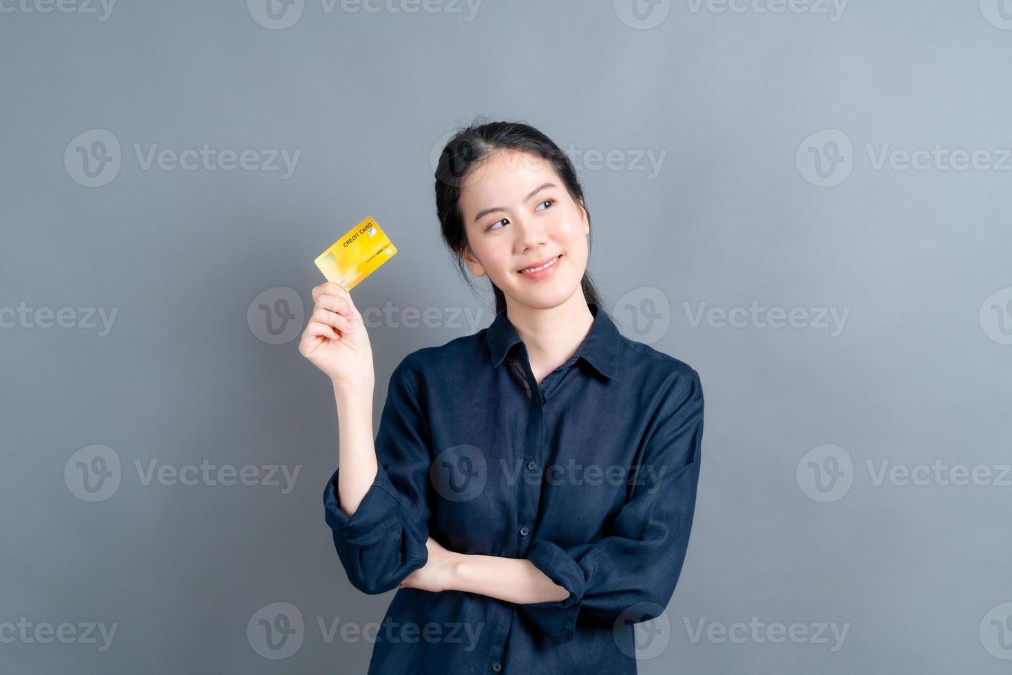 portret van een mooie jonge Aziatische vrouw die creditcard toont foto