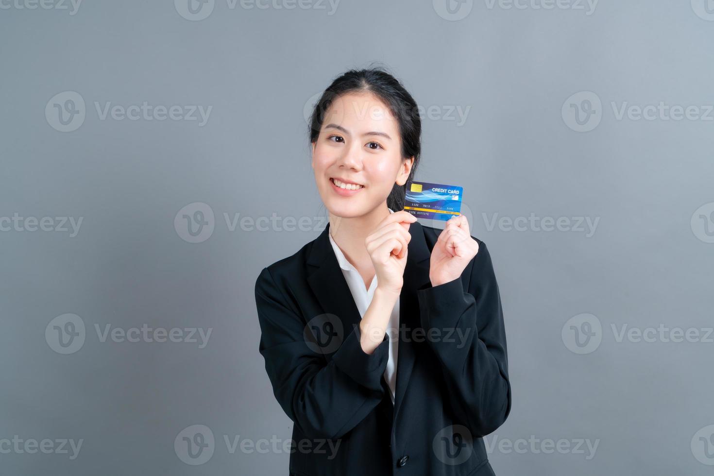 portret van een mooie jonge Aziatische vrouw die creditcard toont foto