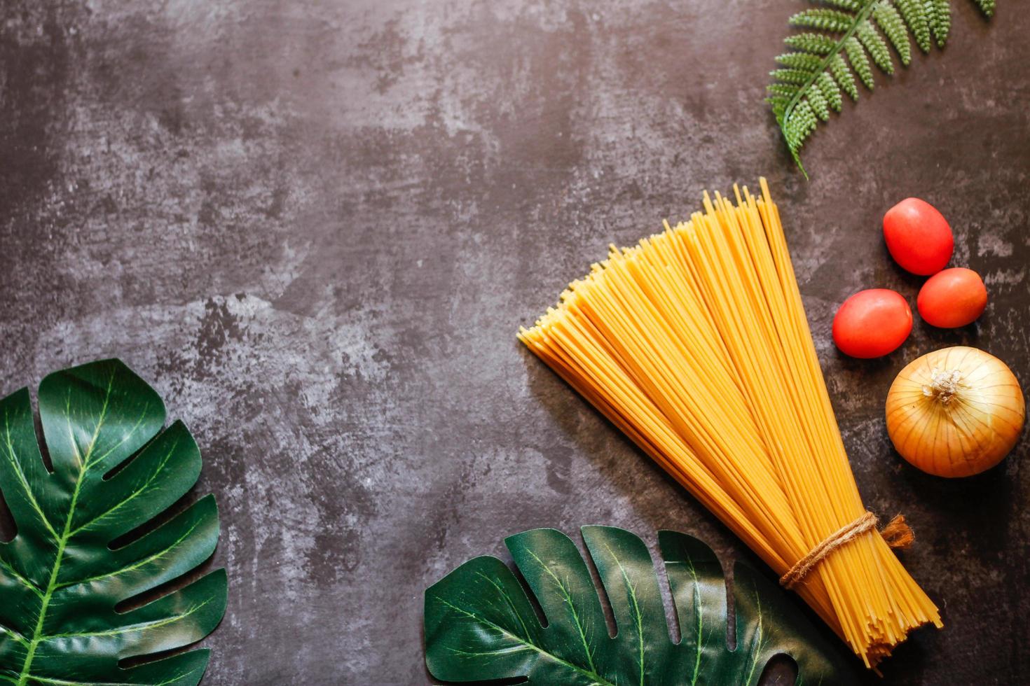 gele lange spaghetti op een rustieke achtergrond. gele Italiaanse pasta. lange spaghetti. rauwe spaghetti bolognese. rauwe spaghetti. voedsel achtergrond concept. Italiaans eten en menuconcept. foto