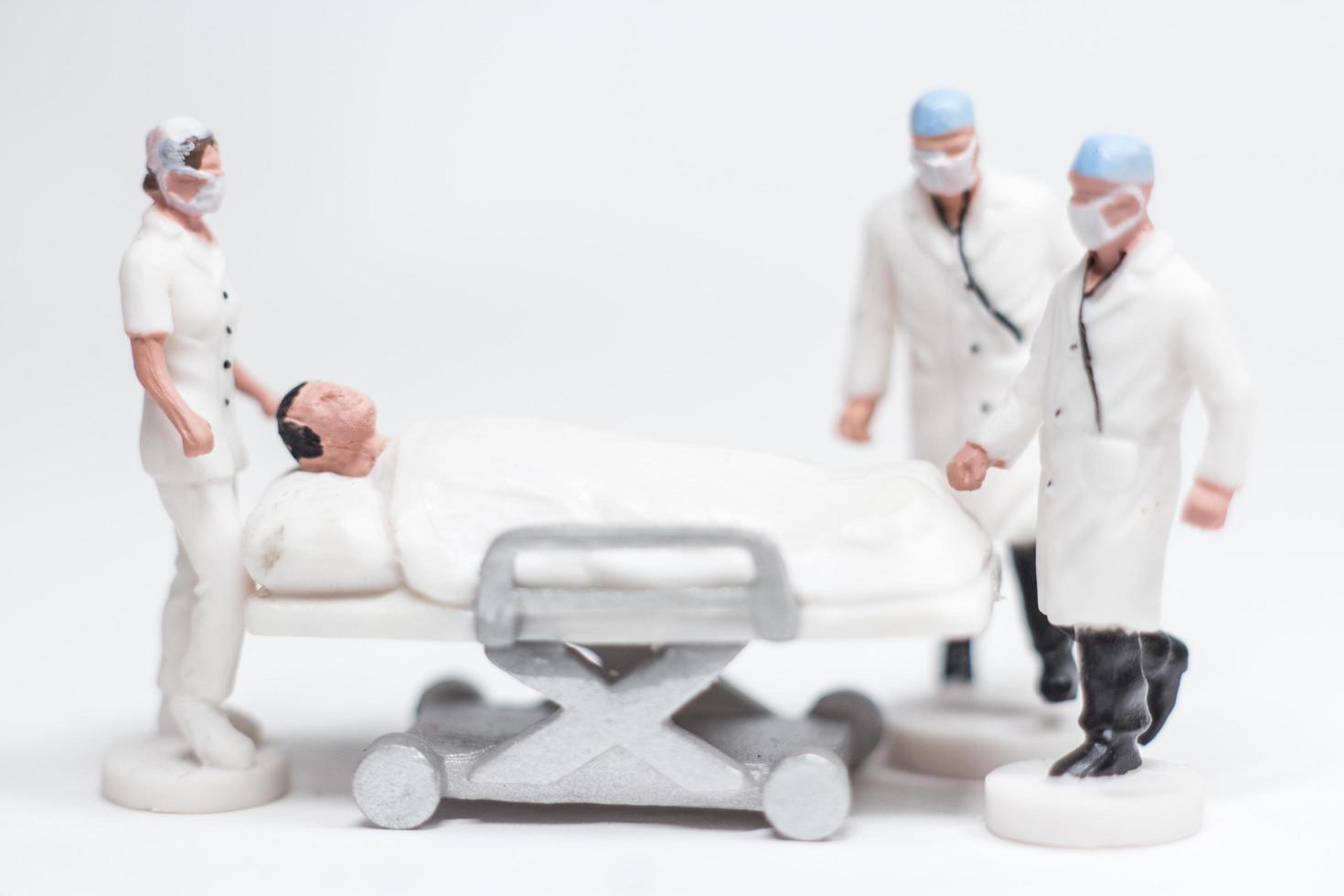 eenvoudige conceptuele foto, minifiguur artsen en verpleegsters minifiguur evacuatie van geïnfecteerde patiënten foto