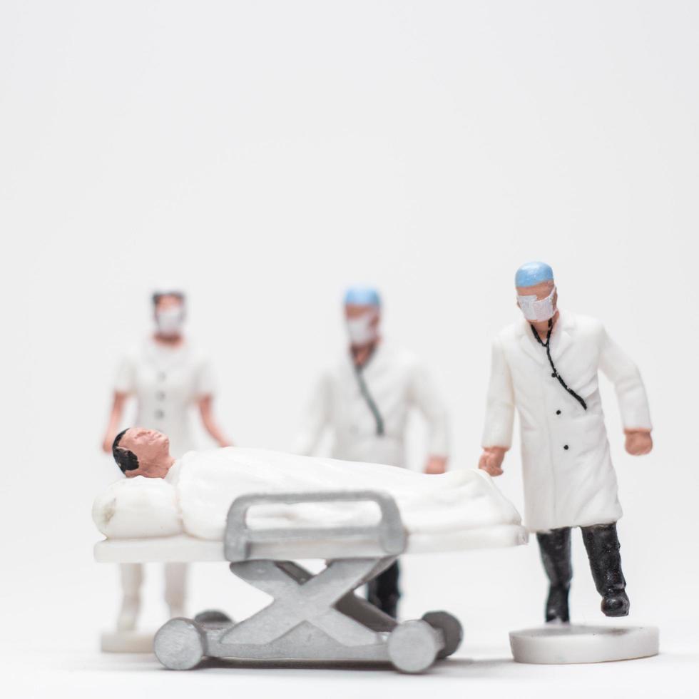 eenvoudige conceptuele foto, minifiguur artsen en verpleegsters minifiguur evacuatie van geïnfecteerde patiënten foto