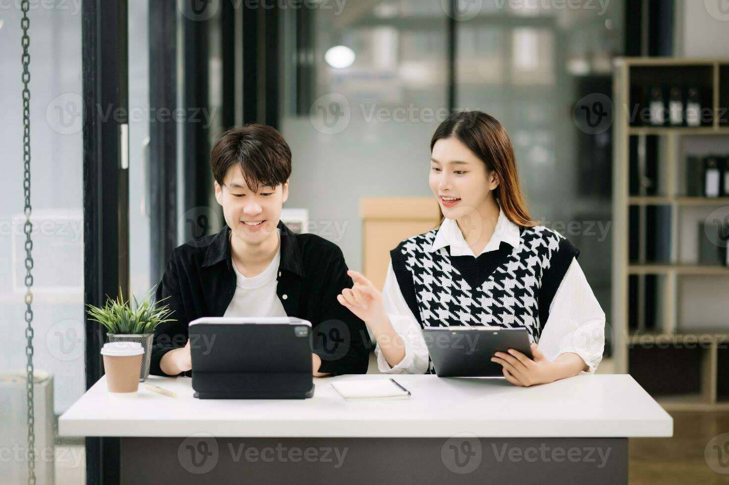 Aziatisch bedrijf collega bedrijf presenteert en legt uit en gebruik makend van laptop en tablet. teamwerk, financieel afzet team, terwijl zittend in modern kantoor kamer. foto