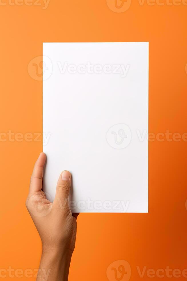 een menselijk hand- Holding een blanco vel van wit papier of kaart geïsoleerd Aan oranje achtergrond. ai gegenereerd foto