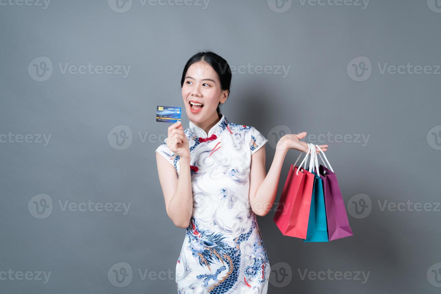 aziatische vrouw draagt chinese traditionele kleding met boodschappentas en creditcard foto