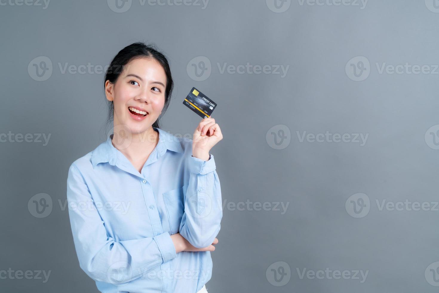 portret van een mooie jonge Aziatische vrouw die creditcard toont foto