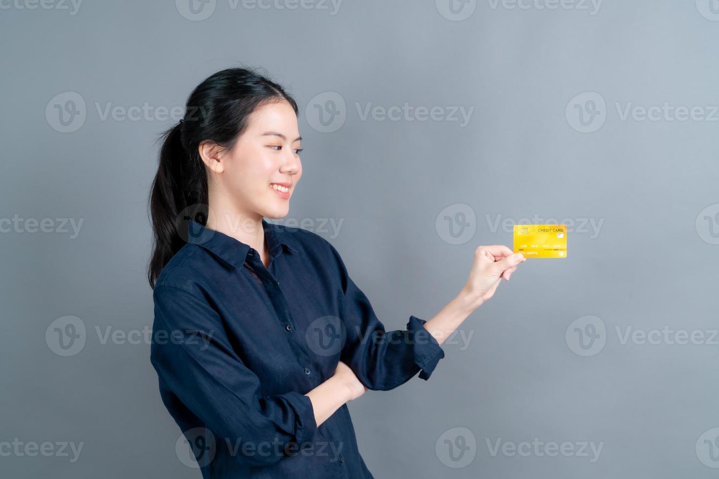 portret van een mooie jonge Aziatische vrouw die creditcard toont foto