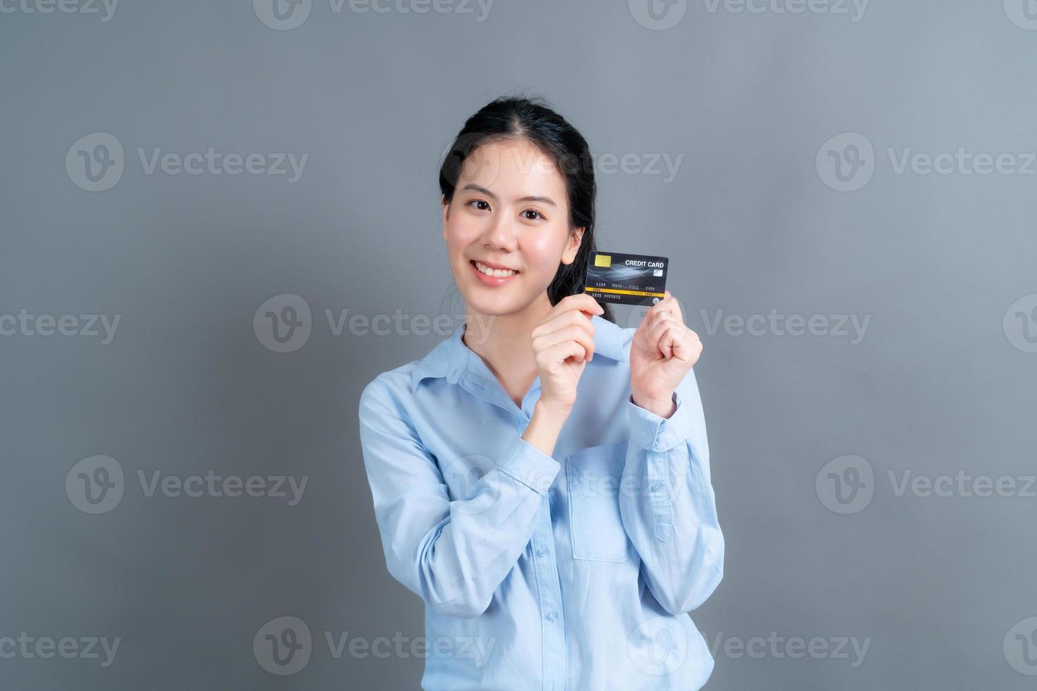 portret van een mooie jonge Aziatische vrouw die creditcard toont foto