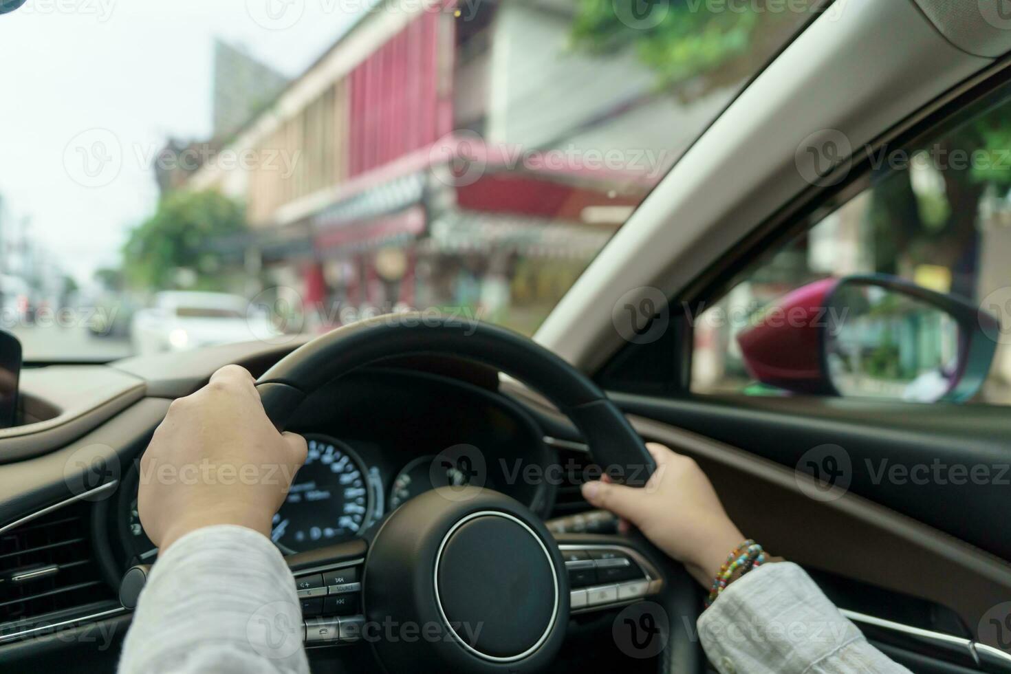 vrouw het rijden auto. meisje gevoel gelukkig naar rit Holding stuurinrichting wiel en op zoek Aan weg foto