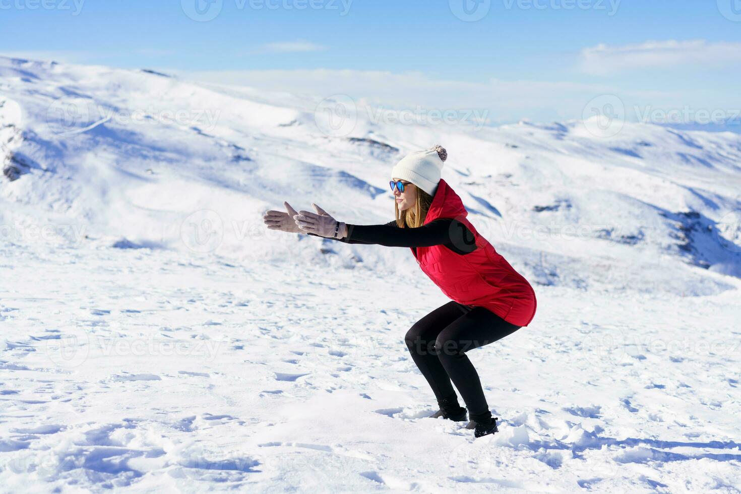 jong vrouw opwarming omhoog lichaam met oefening Aan sneeuw foto