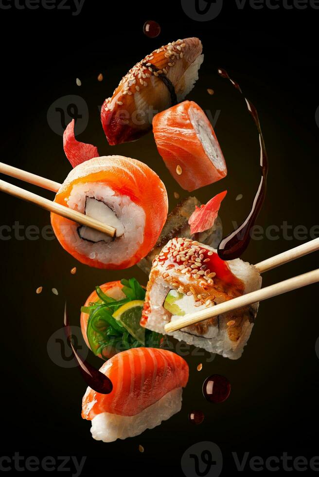 sushi broodjes in assortiment Aan de lucht. concept van levitatie. zwart achtergrond. foto